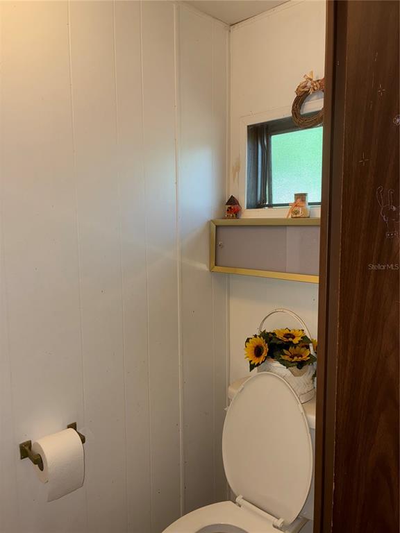 24533 Pink Panther Road Paisley, FL 32767 - Photo 22 of 29 a bathroom with a toilet and a mirror
