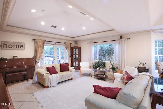 a large living room with stainless steel appliances granite countertop a couch and a large window