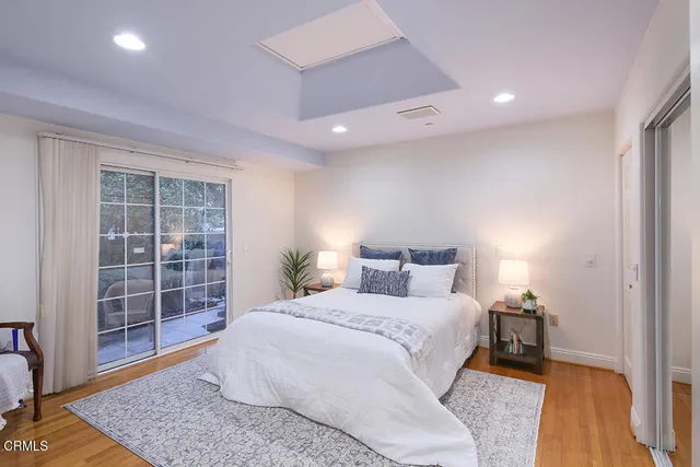 a backyard of a house with table and chairs under an umbrella