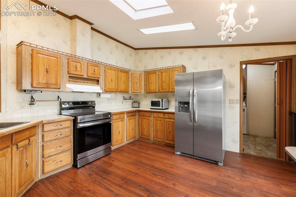13335 Gymkhana Road Peyton, CO 80831 - Photo 19 of 38 Kitchen featuring wood-finish flooring and a full suite of stainless steel appliances