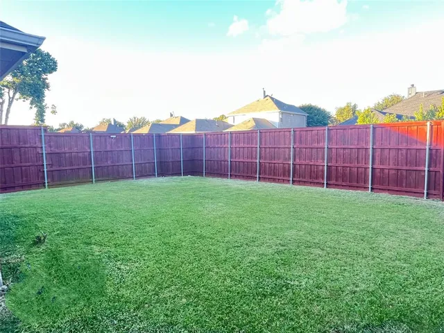 a view of a backyard with a wooden fence