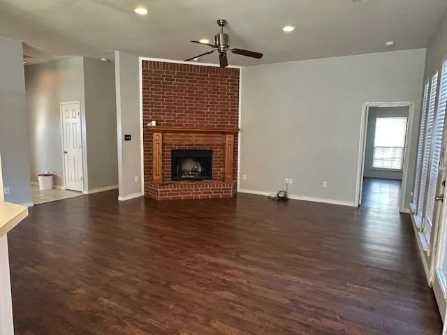 a view of a livingroom with wooden floor and a fireplace