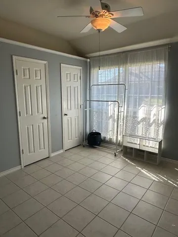 an empty room with windows and fan
