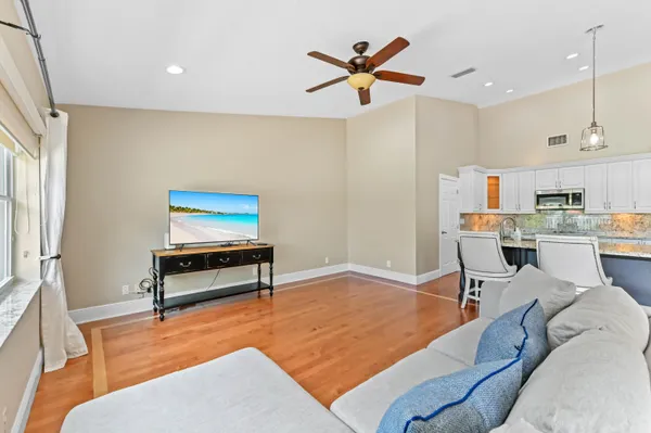 a living room with furniture a rug and kitchen view