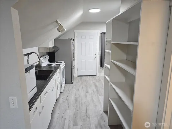 a kitchen with granite countertop a sink a counter space and cabinets