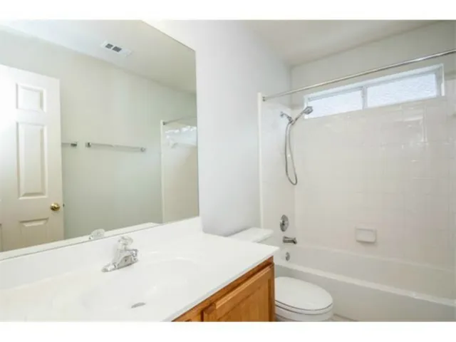 a bathroom with a granite countertop sink a mirror a bathtub and shower