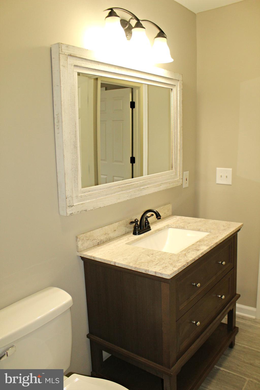 545 Compass Road East Baltimore, MD 21220 - Photo 16 of 30 a bathroom with a granite countertop sink toilet and mirror