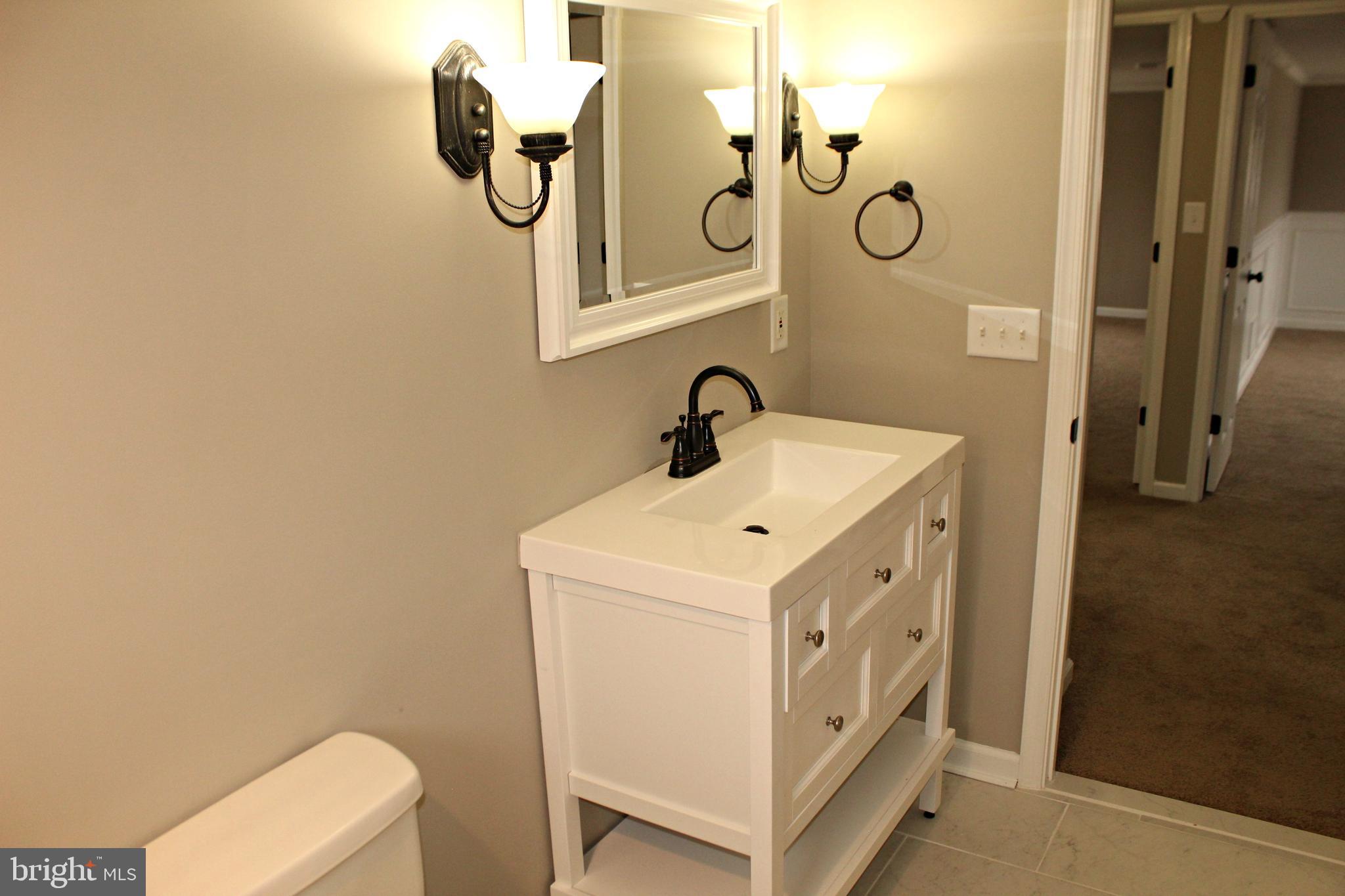 545 Compass Road East Baltimore, MD 21220 - Photo 24 of 30 a bathroom with a sink a toilet and mirror