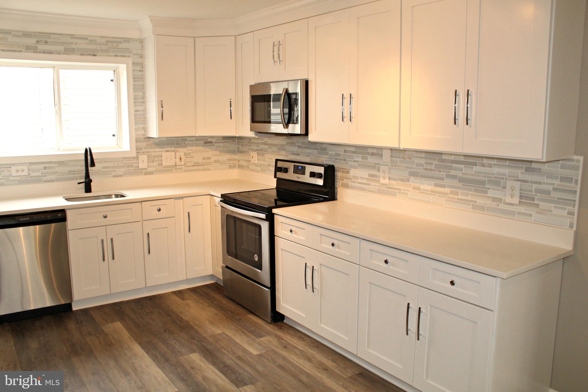 545 Compass Road East Baltimore, MD 21220 - Photo 5 of 30 a kitchen with white cabinets sink and appliances
