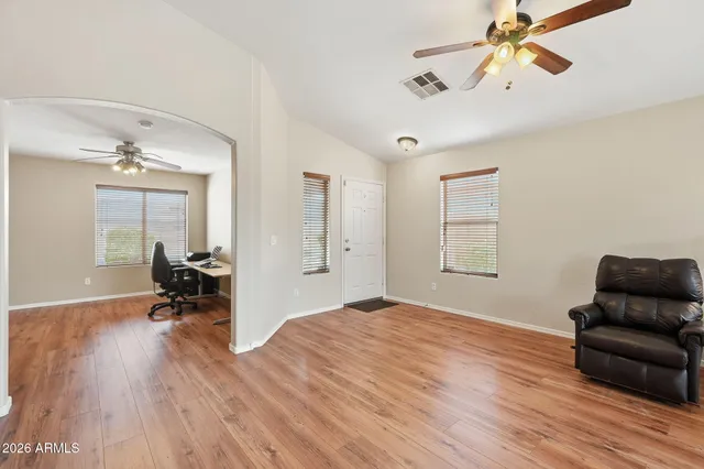 a living room with furniture and a wooden floor