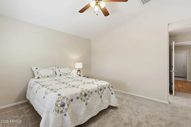 a bedroom with a bed and a ceiling fan