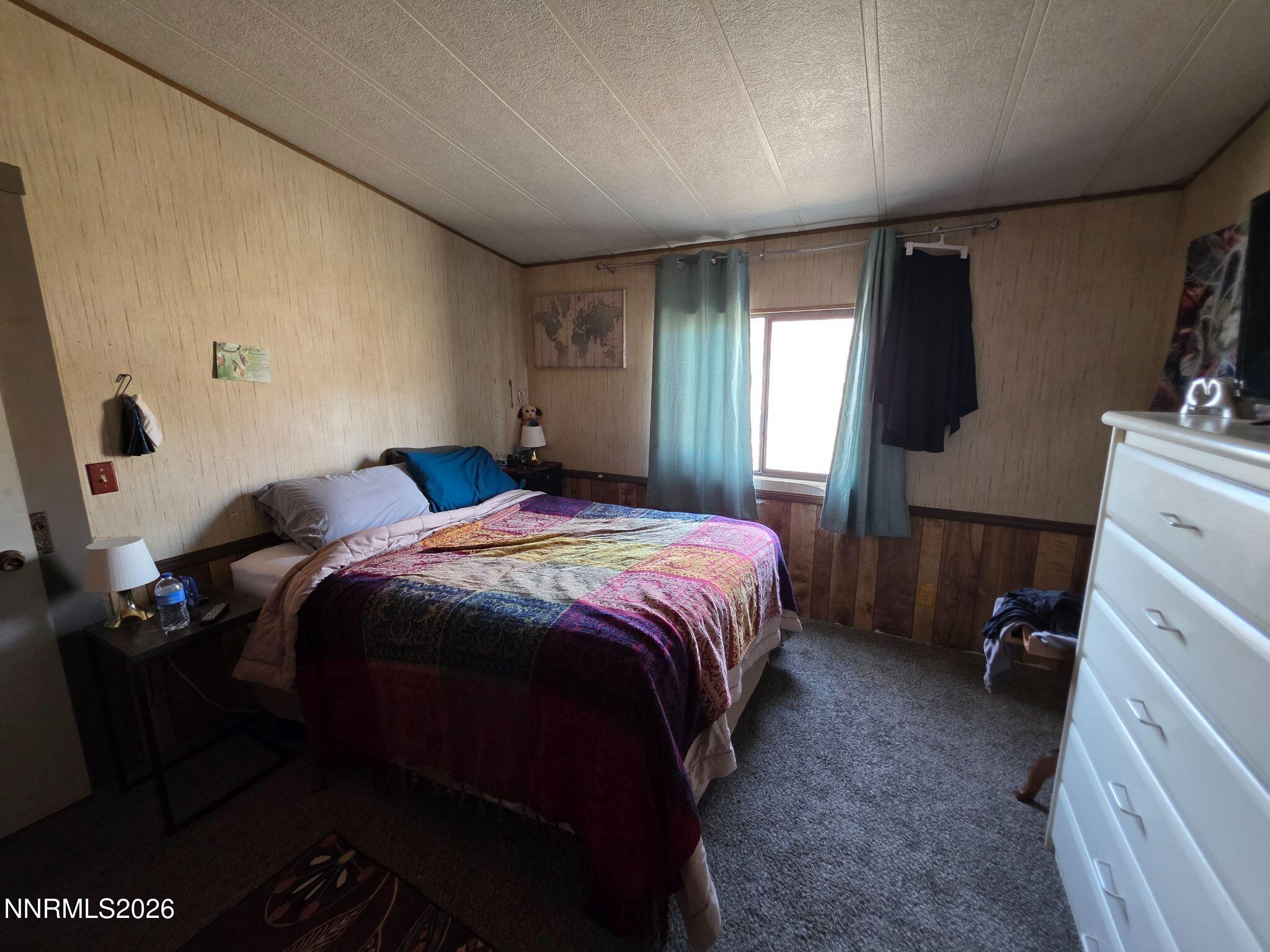 3985 Granite Way Topaz Ranch Estates, NV 89444 - Photo 29 of 34 a bedroom with a bed and a flat tv screen on the dresser