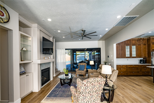 1283 North Gallen Road Santa Clara, UT 84765 - Photo 16 of 103 Living area featuring ceiling fan, light wood finished floors, a glass covered fireplace, a textured ceiling, and recessed lighting