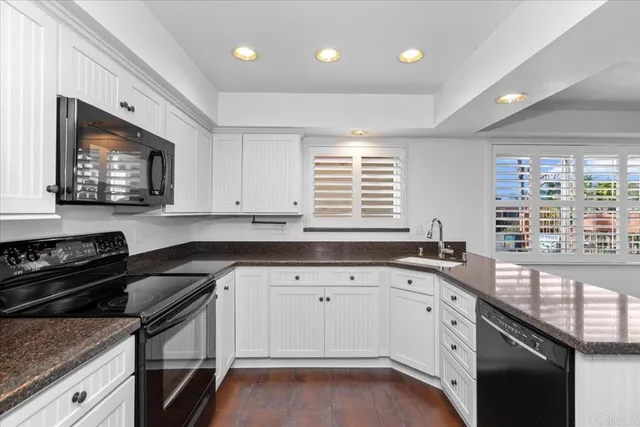 a kitchen with granite countertop a stove a sink and a microwave