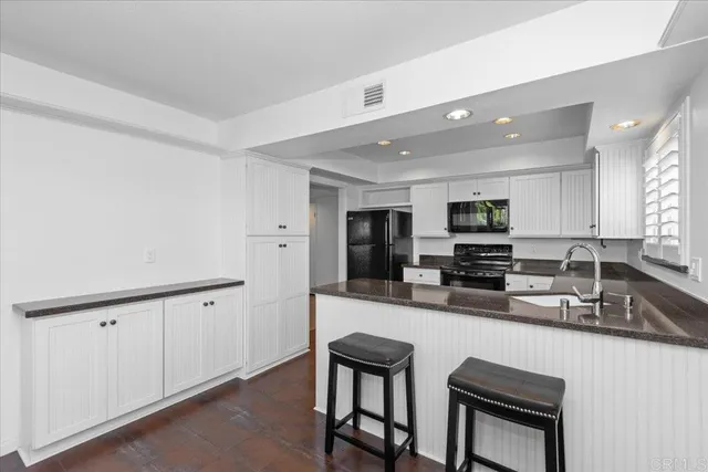 a kitchen with stainless steel appliances a sink stove and cabinets