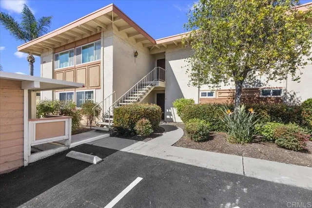 a view of a house with a small yard and potted plants