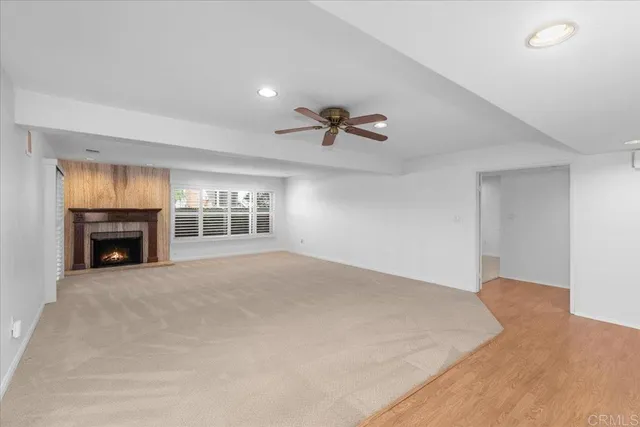 a view of an empty room with a fireplace and a window