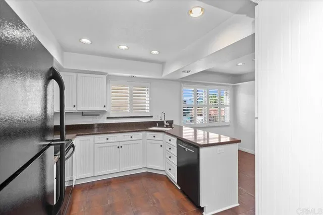 a kitchen with granite countertop a sink stove and cabinets