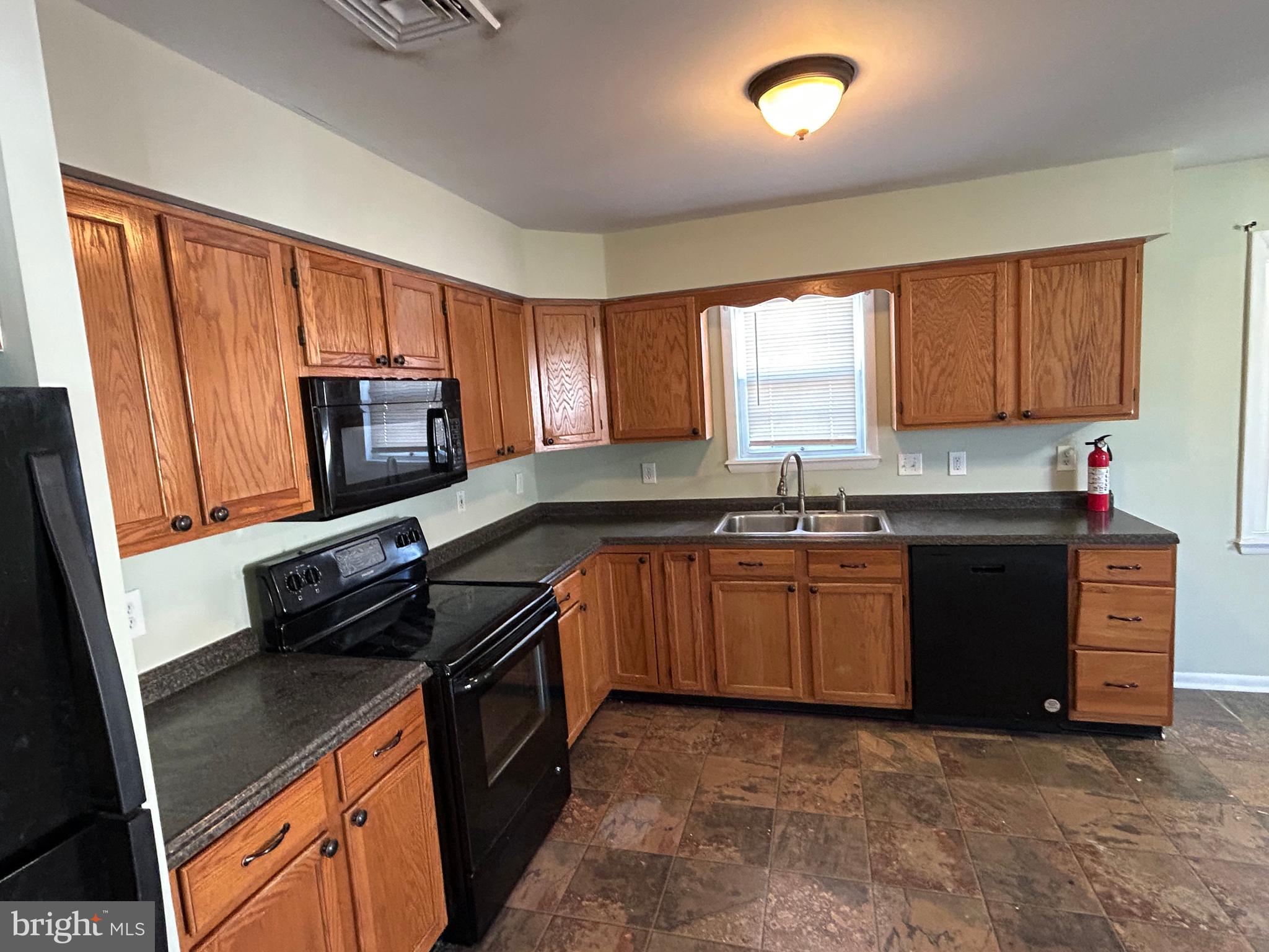 254 G Street Carneys Point, NJ 08069 - Photo 7 of 19 a kitchen with granite countertop a stove top oven sink and cabinets