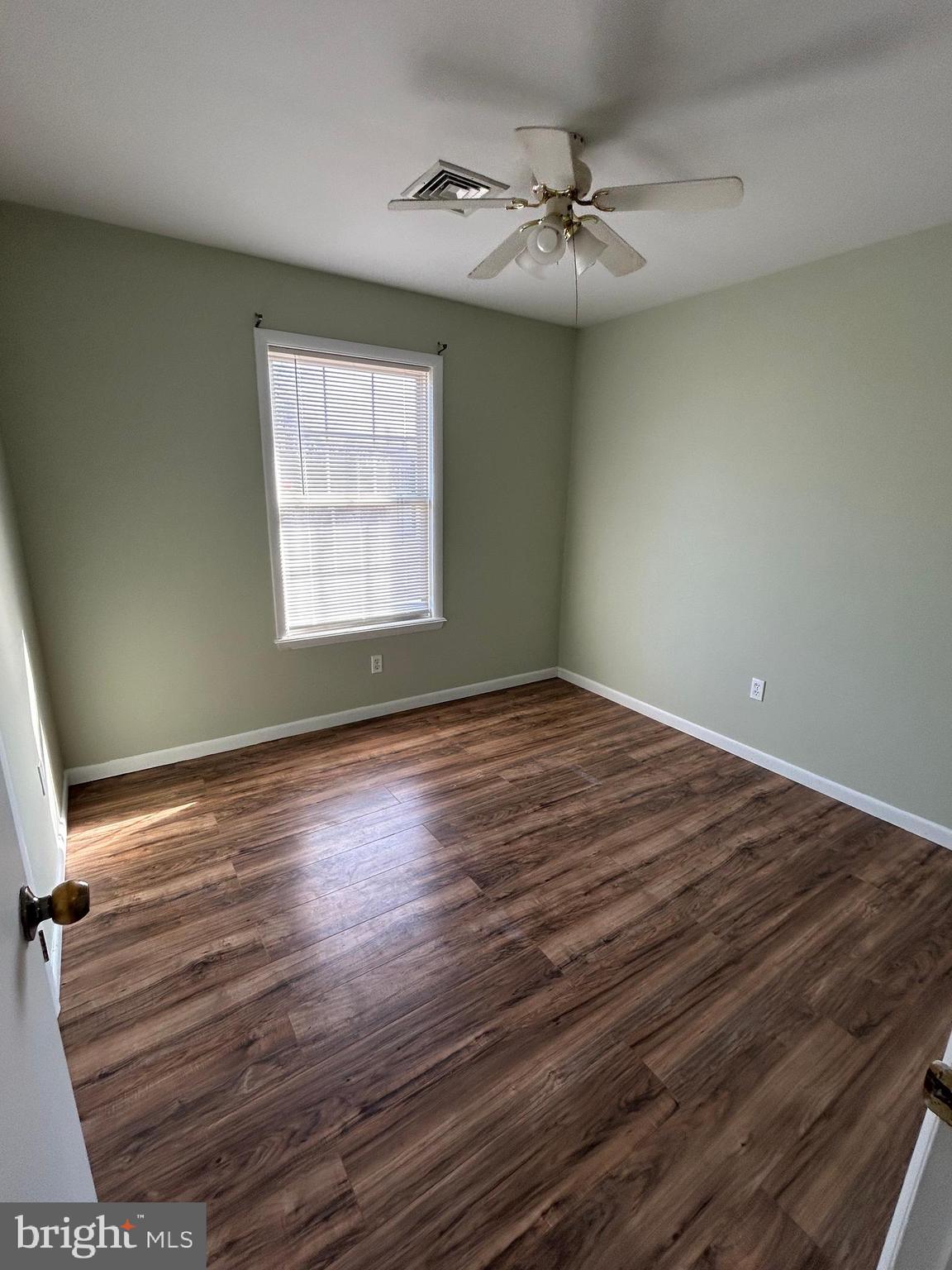 254 G Street Carneys Point, NJ 08069 - Photo 9 of 19 an empty room with wooden floor fan and windows