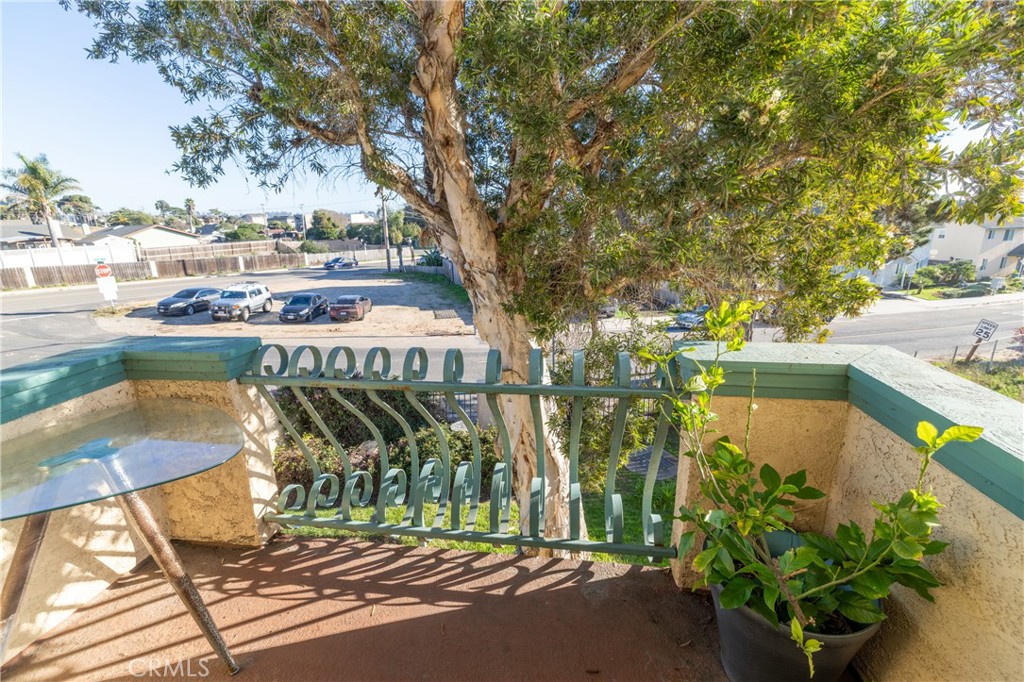 1277 Belridge Street, Unit 1A Oceano, CA 93445 - Photo 20 of 24 a balcony with tall trees
