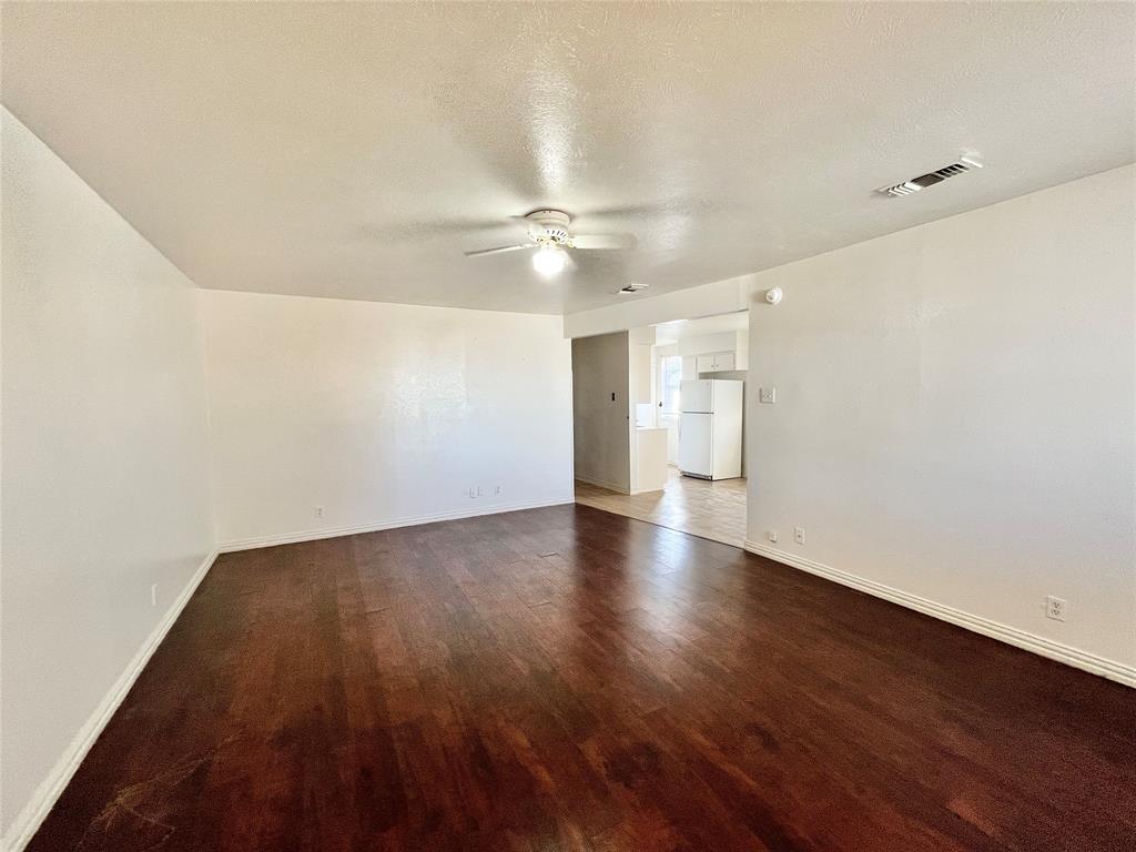 2427 January Lane Grand Prairie, TX 75050 - Photo 2 of 14 wooden floor in an empty room with a window