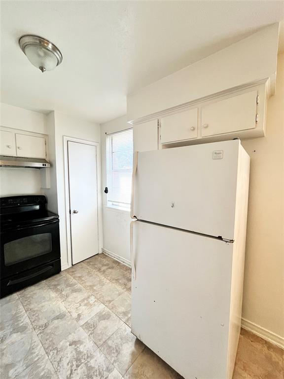 2427 January Lane Grand Prairie, TX 75050 - Photo 6 of 14 a white refrigerator freezer and a stove sitting inside of a kitchen