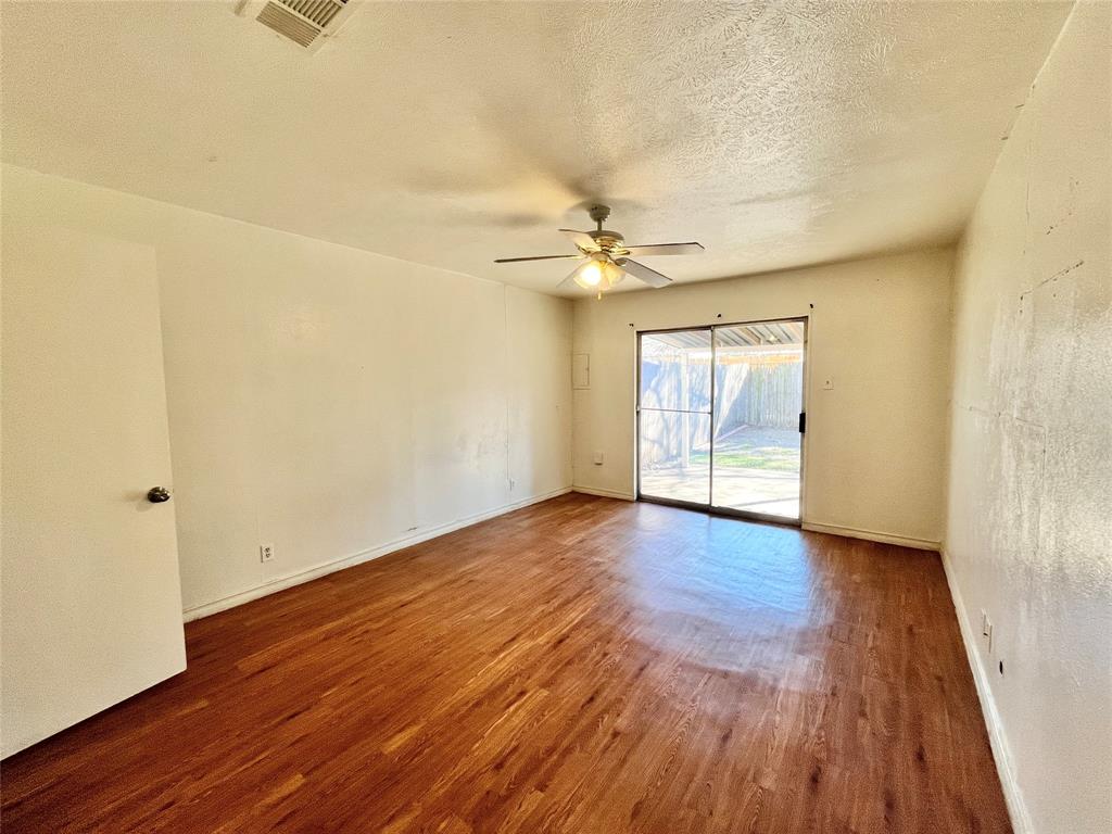 2427 January Lane Grand Prairie, TX 75050 - Photo 7 of 14 an empty room with wooden floor and windows