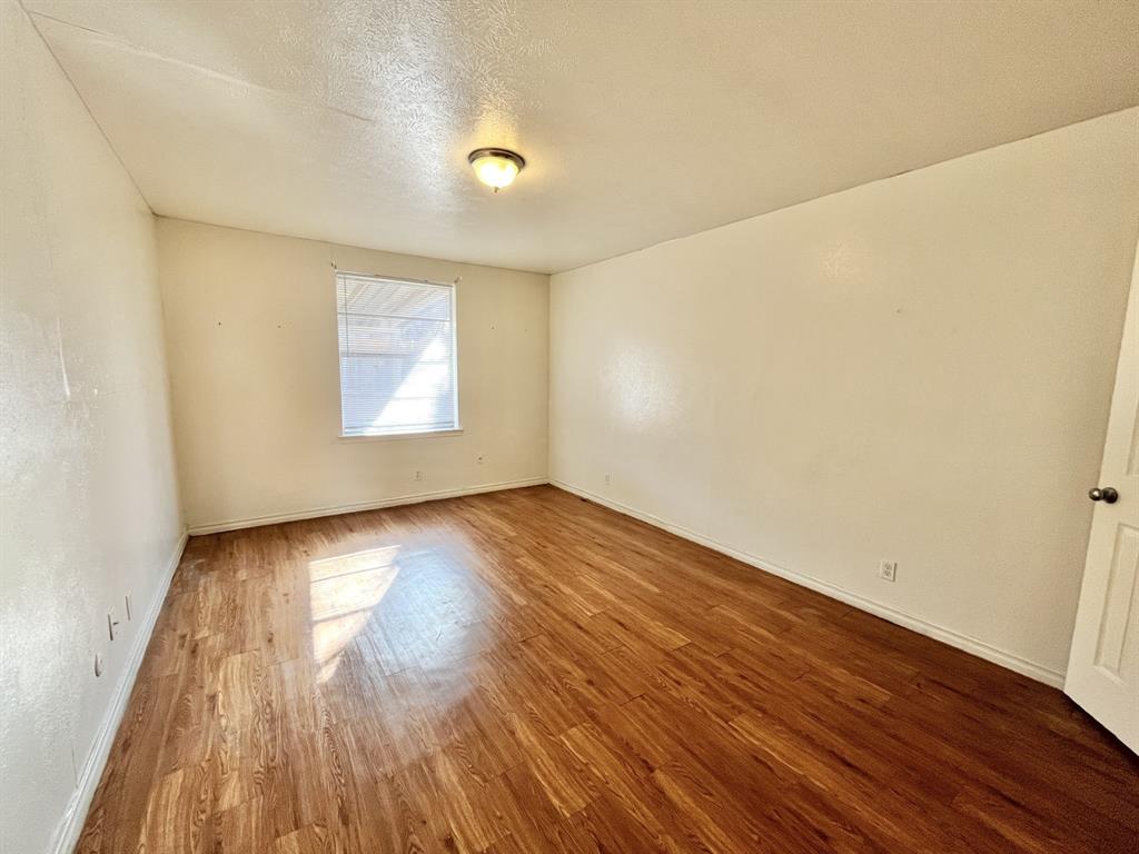 2427 January Lane Grand Prairie, TX 75050 - Photo 10 of 14 an empty room with wooden floor and windows