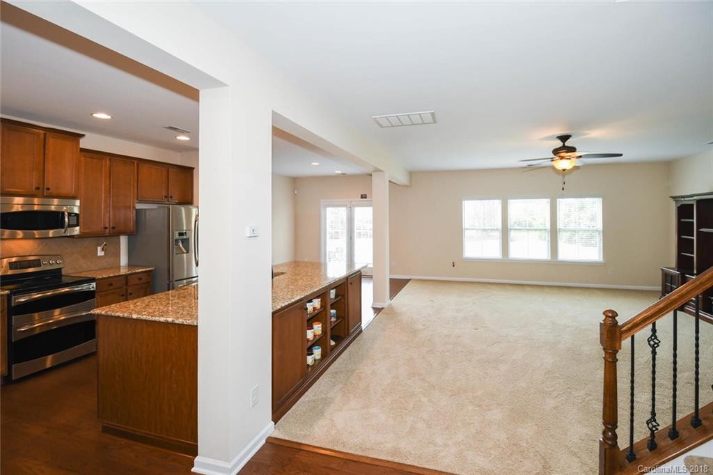 1700 Ridgehaven Road Waxhaw, NC 28173 - Photo 9 of 27 a kitchen with stainless steel appliances granite countertop a refrigerator a stove and a sink with wooden floor
