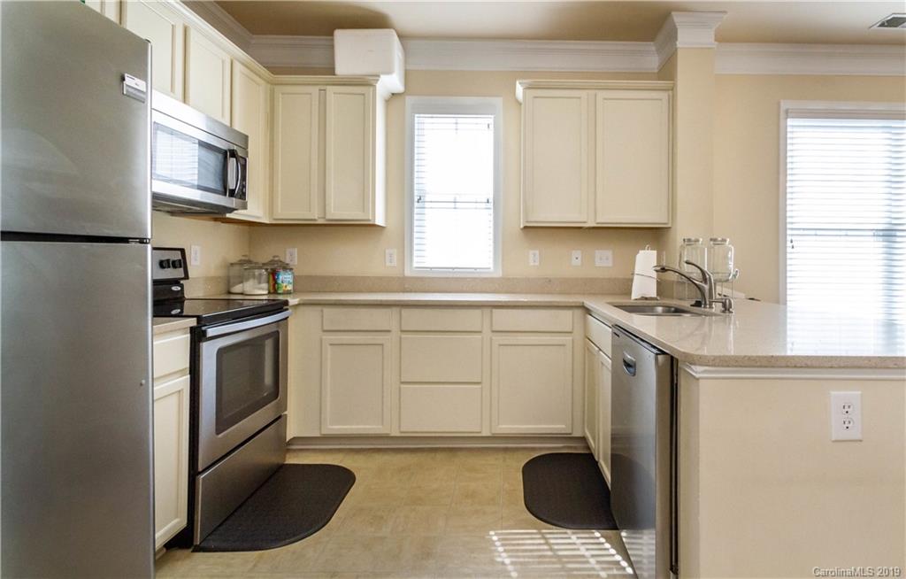 a kitchen with stainless steel appliances granite countertop a sink a stove and a microwave