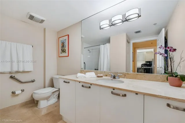 a bathroom with a sink a toilet and mirror