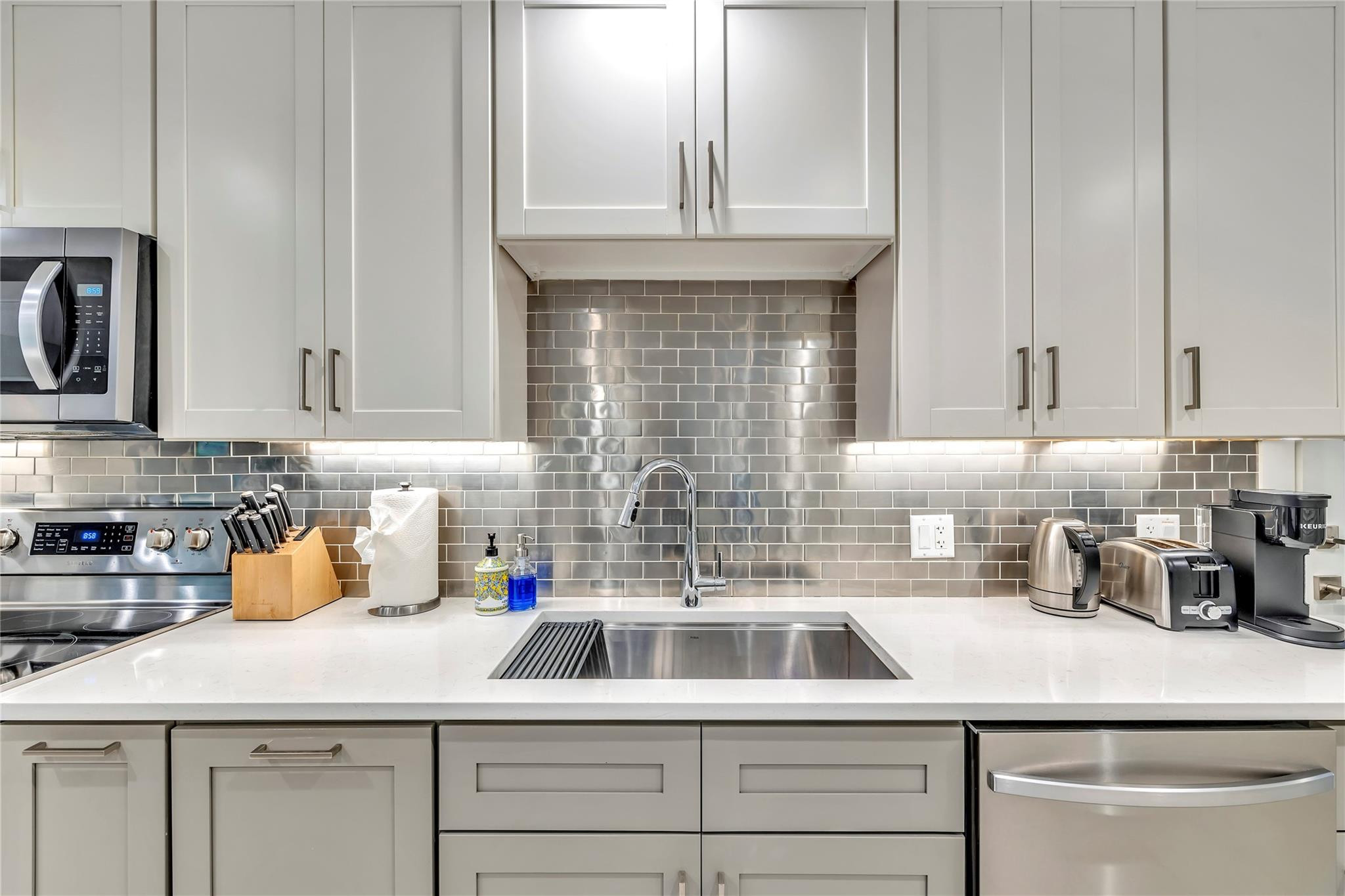 2120 Northeast 34th Court Lighthouse Point, FL 33064 - Photo 13 of 34 a kitchen with stainless steel appliances a sink dishwasher and white cabinets