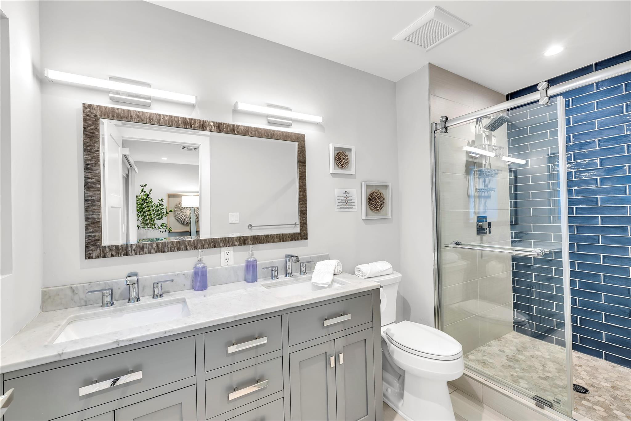 2120 Northeast 34th Court Lighthouse Point, FL 33064 - Photo 18 of 34 a bathroom with a granite countertop sink toilet mirror and shower
