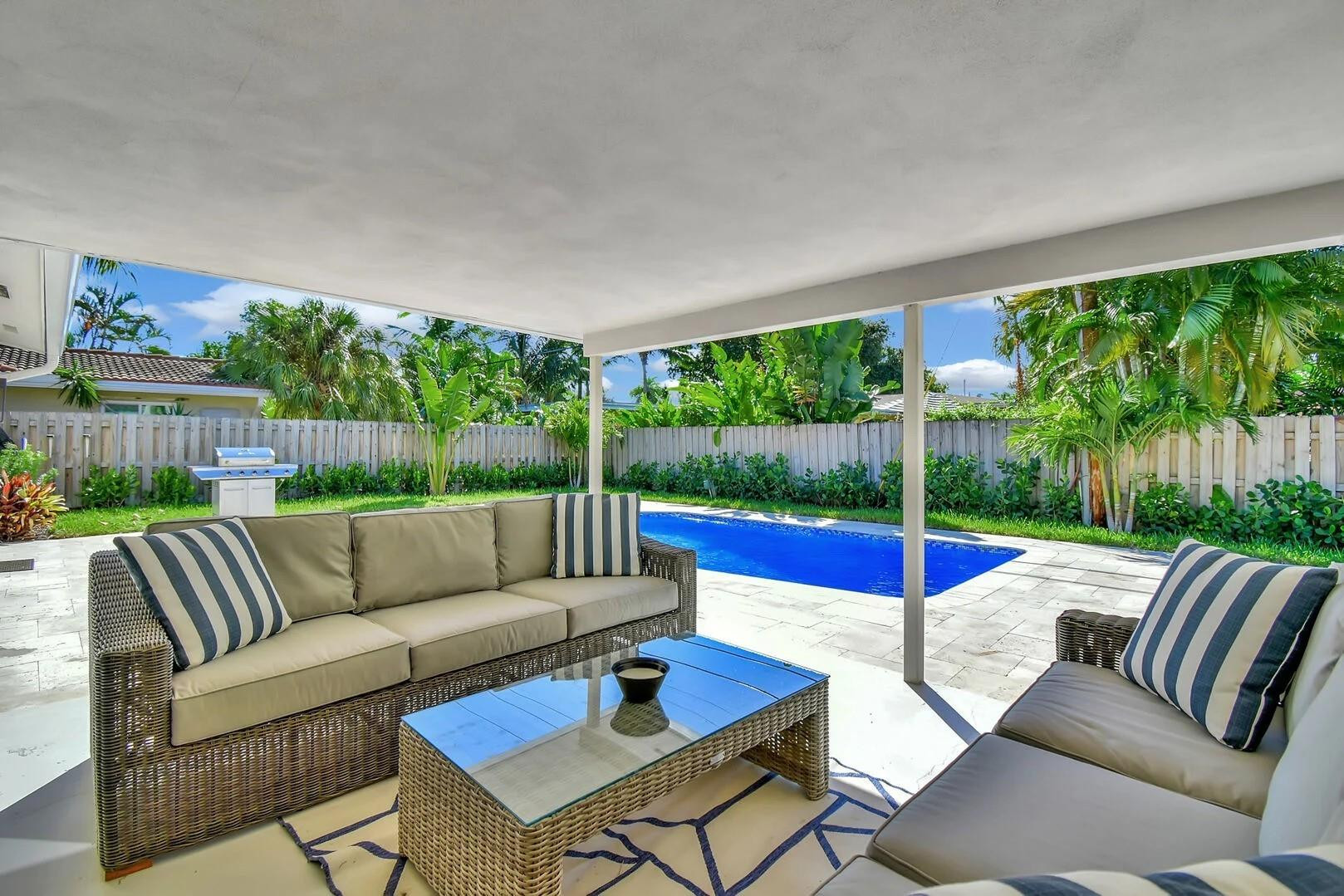 2120 Northeast 34th Court Lighthouse Point, FL 33064 - Photo 27 of 34 a view of a patio with couches potted plants and wooden floor