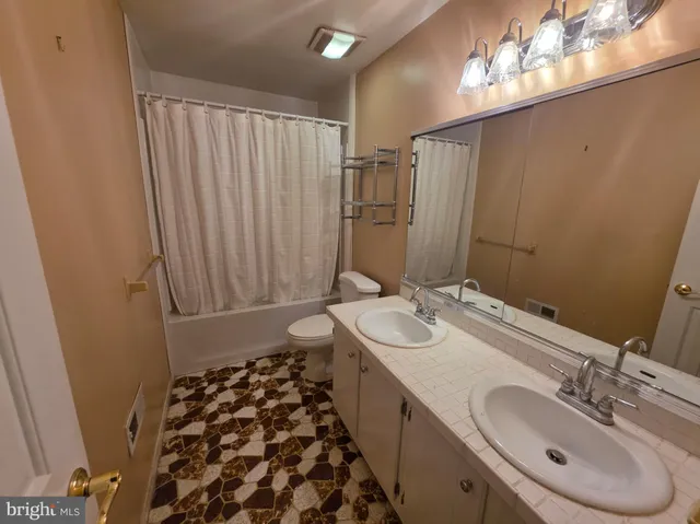 a bathroom with a double vanity sink and a mirror