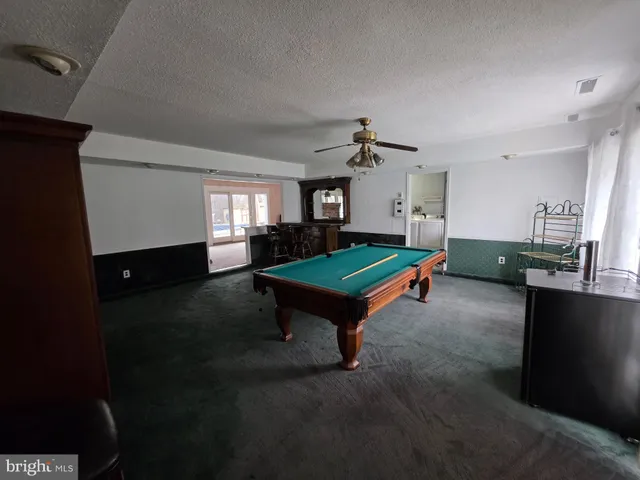 a room with pool table and windows