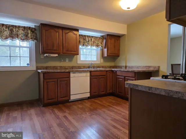 a kitchen with a sink a window and cabinets
