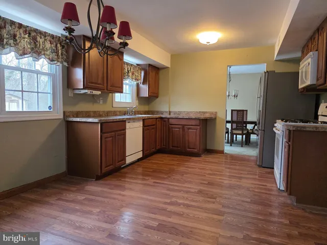 a large kitchen with stainless steel appliances granite countertop a sink and cabinets