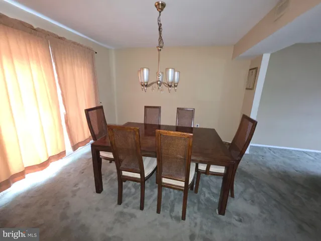 a dining room with furniture a chandelier and a window