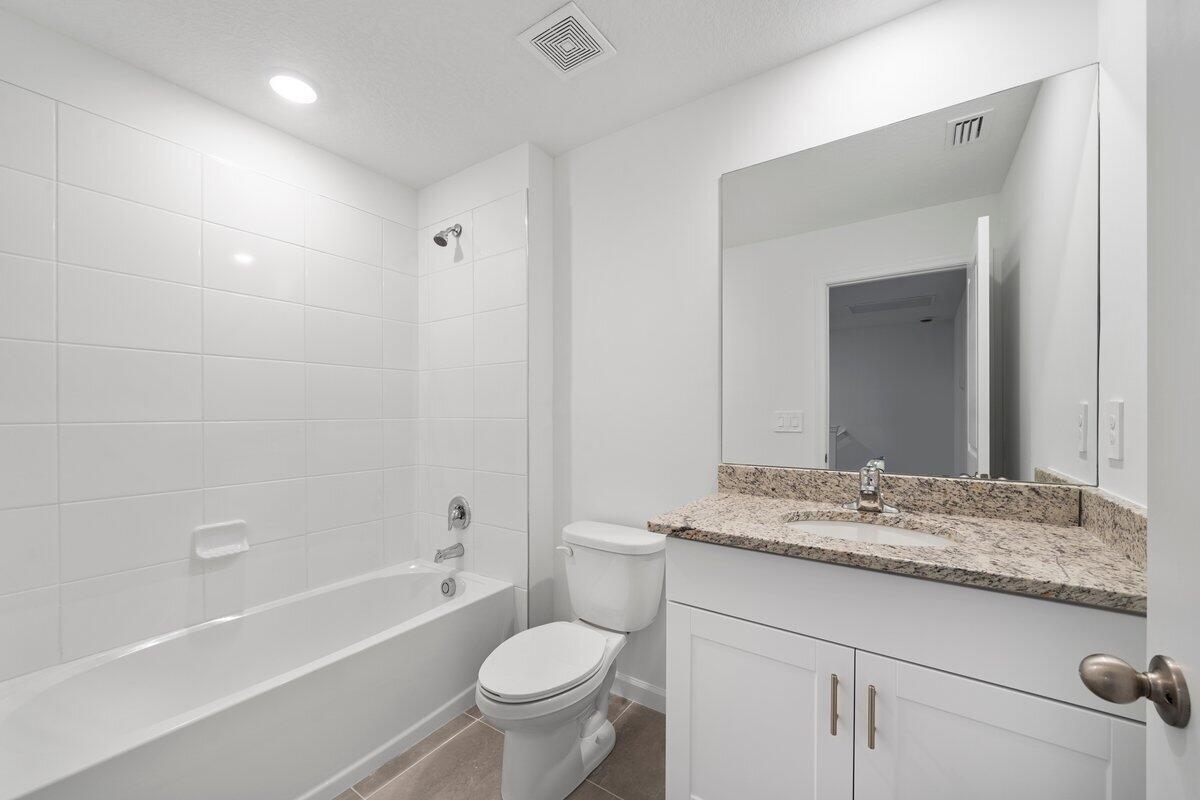 474 Salisbury Circle Fort Pierce, FL 34982 - Photo 10 of 17 a bathroom with a granite countertop sink toilet mirror and bathtub