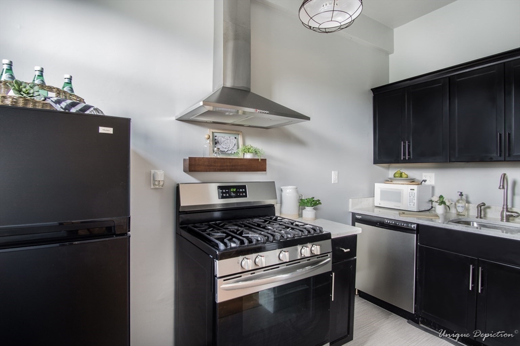 354 North Main Street, Unit 303 Andover, MA 01810 - Photo 13 of 16 a kitchen with stainless steel appliances kitchen island a stove and a refrigerator