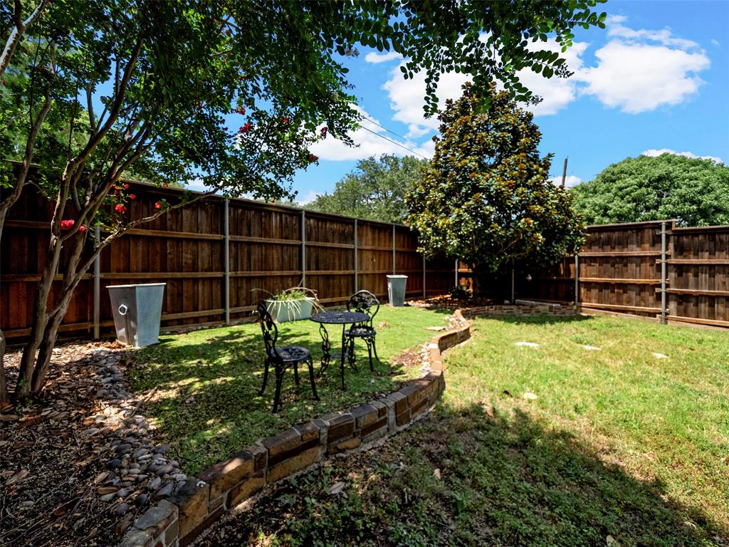 204 Arbor Ridge Drive Allen, TX 75002 - Photo 31 of 36 Fenced backyard with mature trees, a manicured lawn, and brick retaining walls