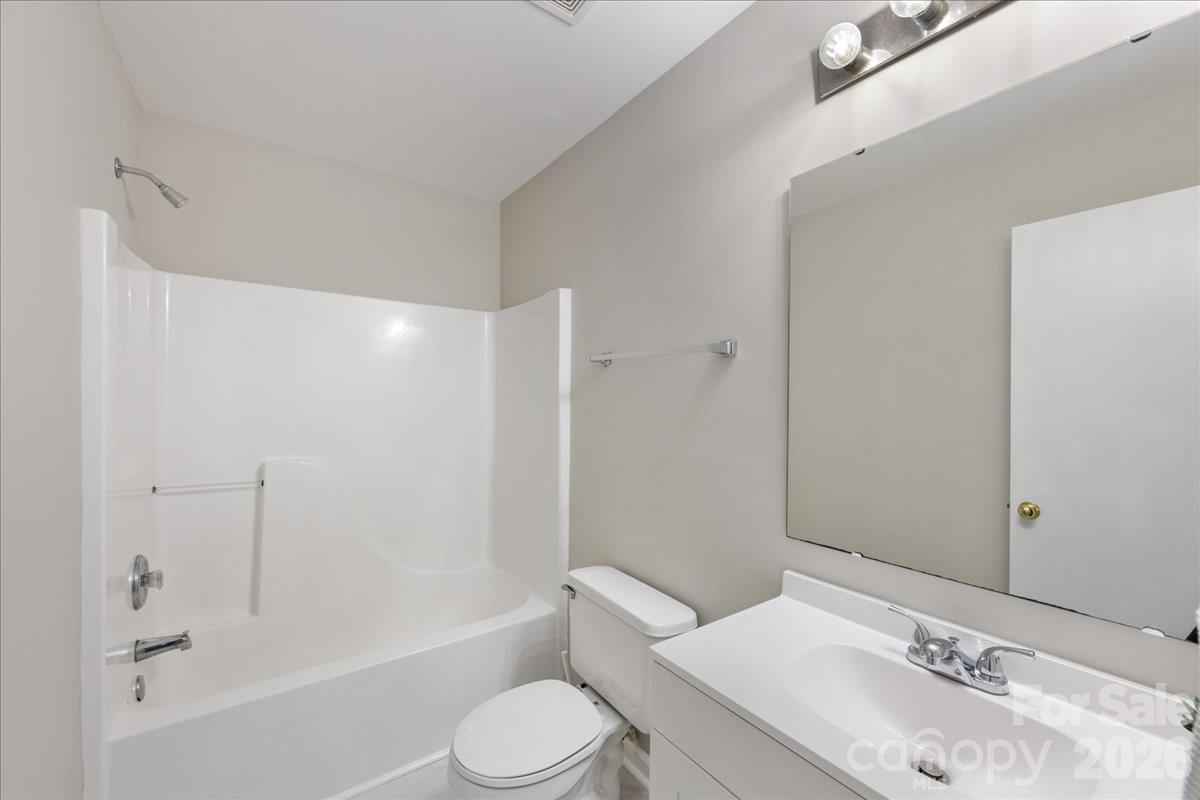 2872 Signal Court Southwest Concord, NC 28025 - Photo 32 of 43 a bathroom with a bathtub shower sink vanity mirror and toilet