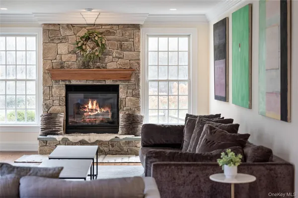 a living room with furniture a fireplace and a large window