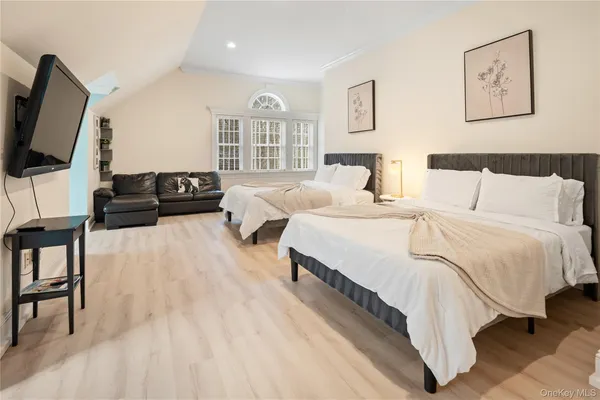 a spacious bedroom with a bed and a flat screen tv