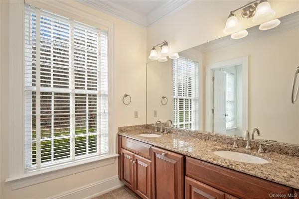 a bathroom with a granite countertop sink a large mirror and a window