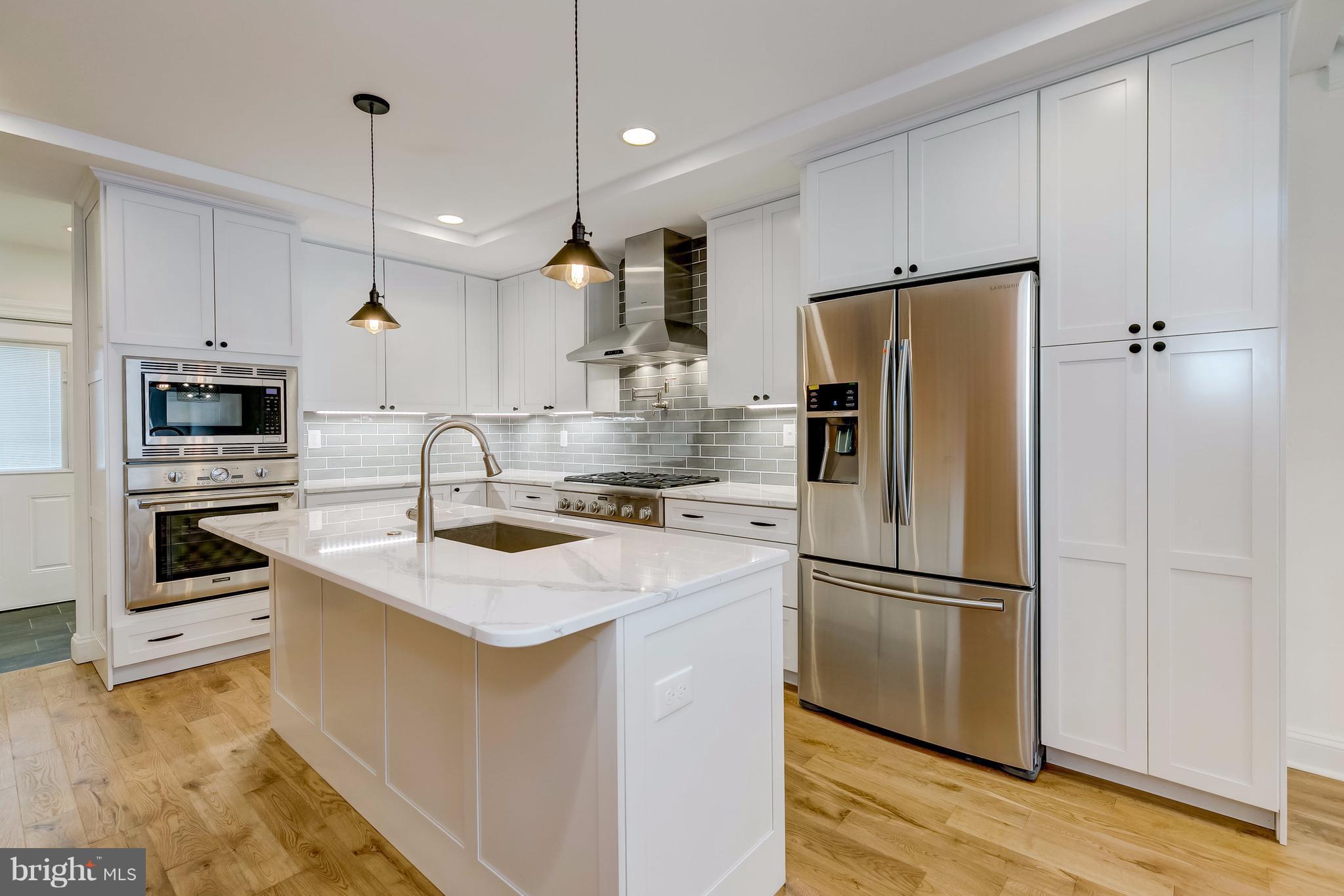 a kitchen with kitchen island a sink appliances and cabinets