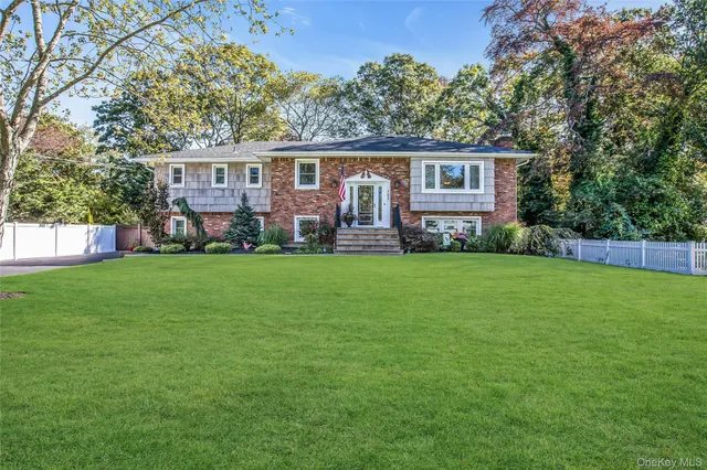 a front view of a house with a yard and trees