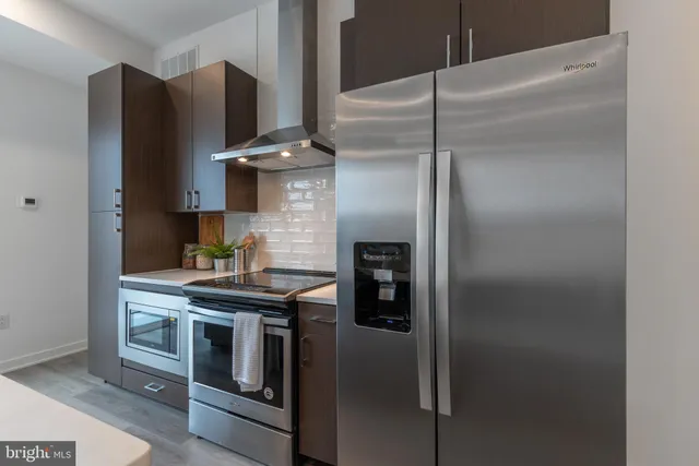 a kitchen with stainless steel appliances granite countertop a refrigerator and a stove